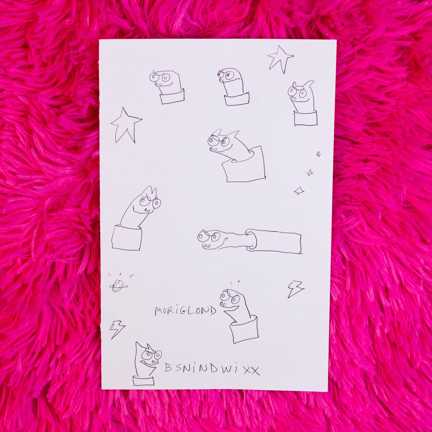Sheet of paper with black line art on a pink textured surface