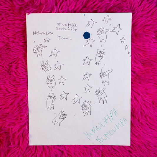 Sheet of paper with drawings and text on a pink textured surface